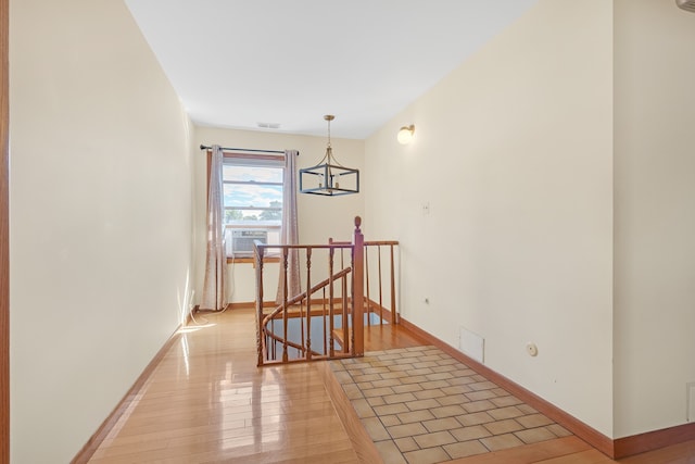 unfurnished room featuring a notable chandelier, cooling unit, and light hardwood / wood-style flooring