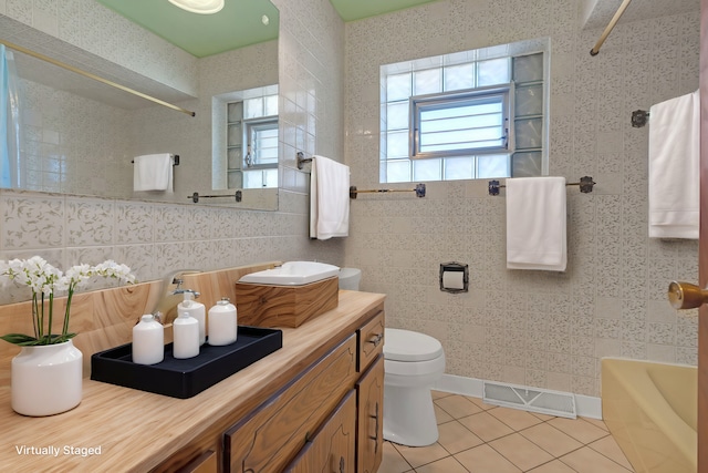 full bathroom featuring tile walls, vanity, toilet, and tile patterned flooring