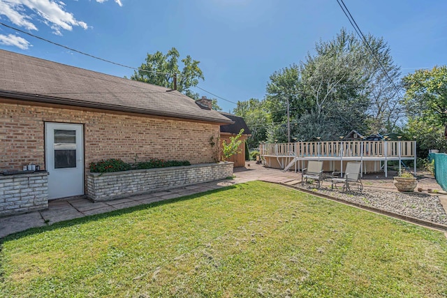 view of yard with a wooden deck and a patio area