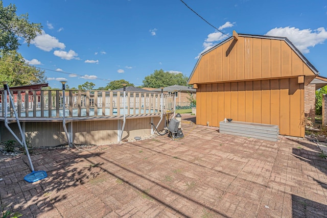 view of patio with a storage shed and a deck