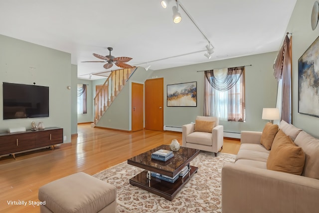 living room with baseboard heating, hardwood / wood-style floors, track lighting, and ceiling fan