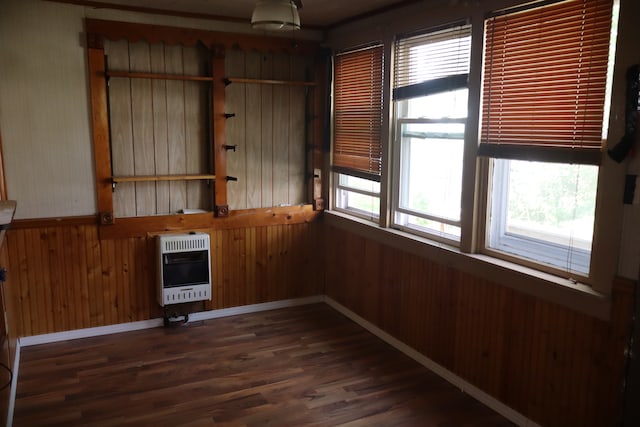 spare room featuring wooden walls, dark hardwood / wood-style flooring, and heating unit