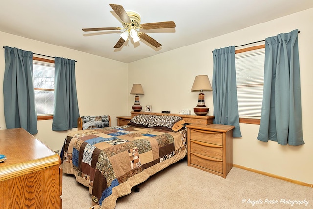 bedroom with ceiling fan, baseboards, and light colored carpet