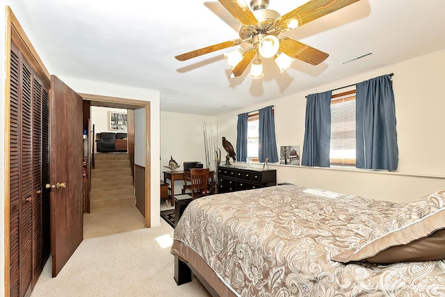 bedroom with light carpet, a closet, visible vents, and a ceiling fan