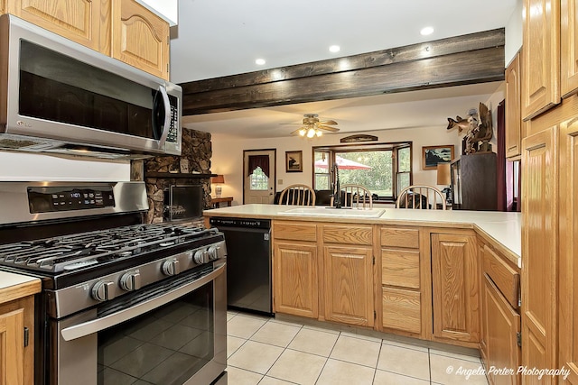 kitchen featuring light countertops, light tile patterned flooring, a sink, and stainless steel appliances