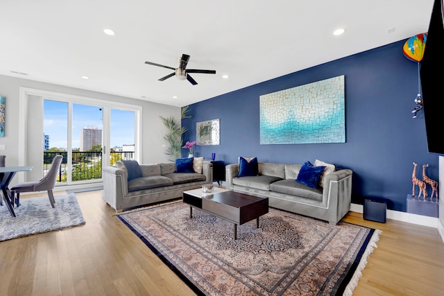 living room with ceiling fan and light hardwood / wood-style flooring