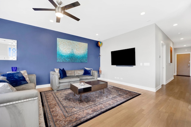 living room featuring ceiling fan and light hardwood / wood-style flooring