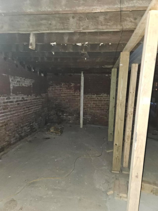 basement featuring brick wall