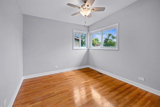 spare room featuring light hardwood / wood-style flooring, lofted ceiling, and ceiling fan