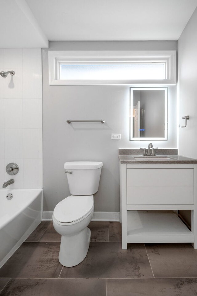 full bathroom with tiled shower / bath, vanity, and toilet