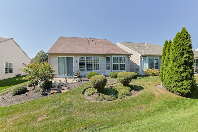 rear view of house featuring a patio and a yard