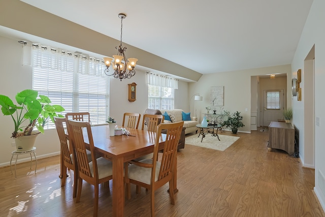 dining room featuring light wood-type flooring and a chandelier