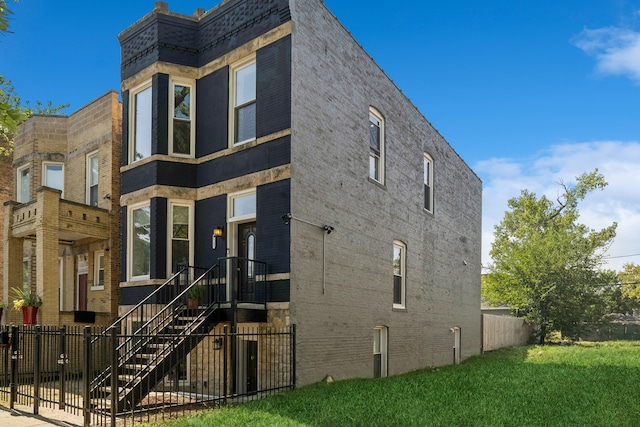 view of home's exterior featuring a yard, brick siding, and fence