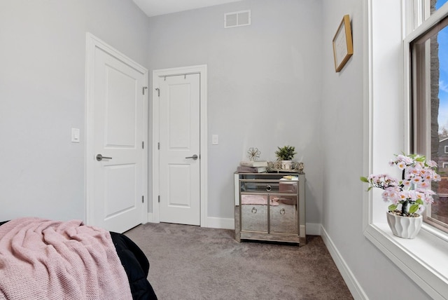 carpeted bedroom featuring multiple windows, visible vents, and baseboards