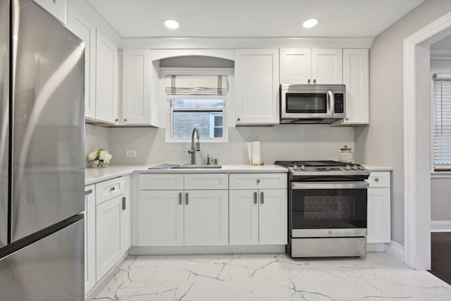 kitchen with white cabinetry, sink, and stainless steel appliances