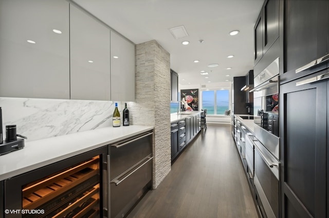 kitchen with backsplash, stainless steel oven, beverage cooler, dark hardwood / wood-style floors, and sink