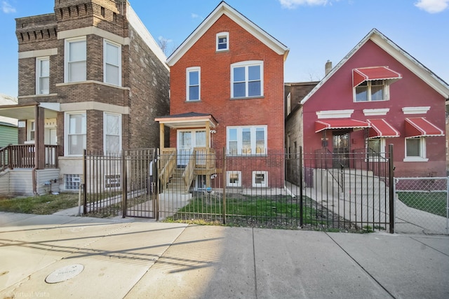 view of front facade featuring brick siding and a fenced front yard