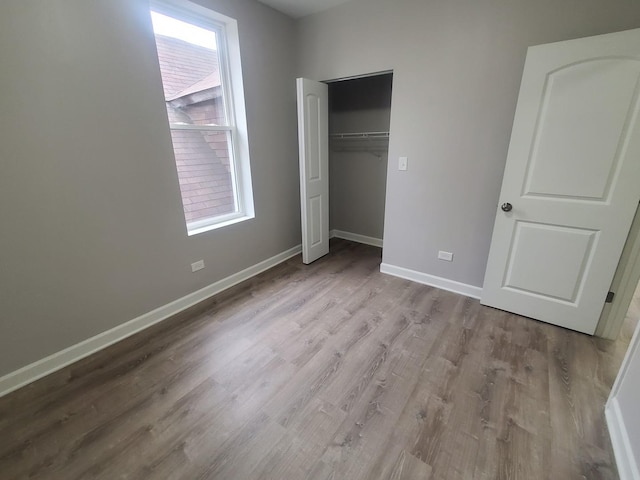 unfurnished bedroom with light wood-type flooring and a closet