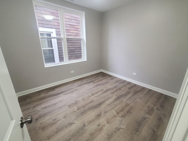 empty room featuring wood finished floors and baseboards