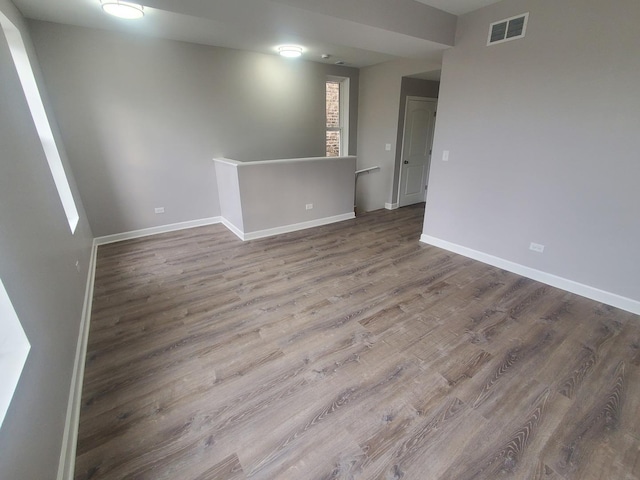 empty room featuring visible vents, baseboards, and wood finished floors