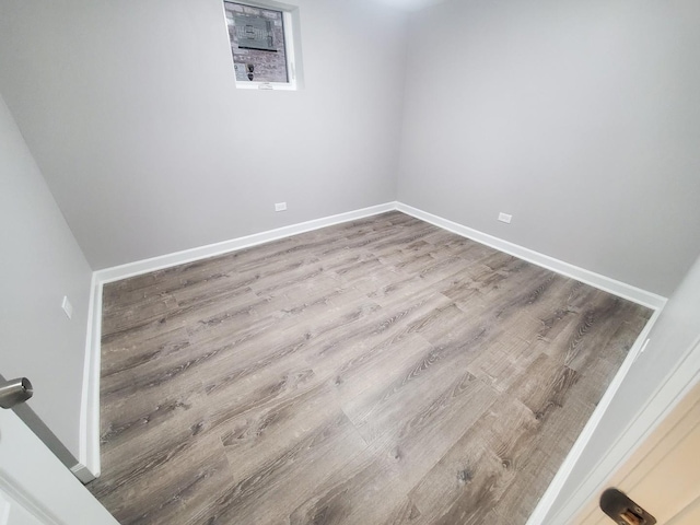 spare room featuring baseboards and wood finished floors