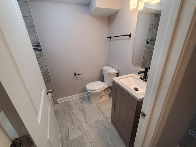 bathroom with vanity, toilet, and baseboards