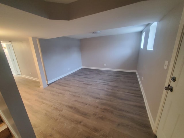 basement with baseboards and wood finished floors