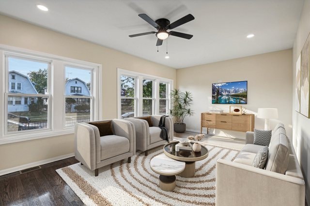 living room featuring dark wood-type flooring and ceiling fan