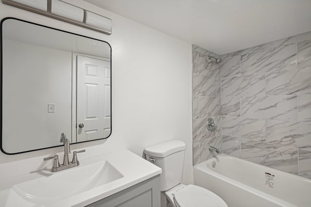 full bathroom featuring vanity, tiled shower / bath combo, and toilet