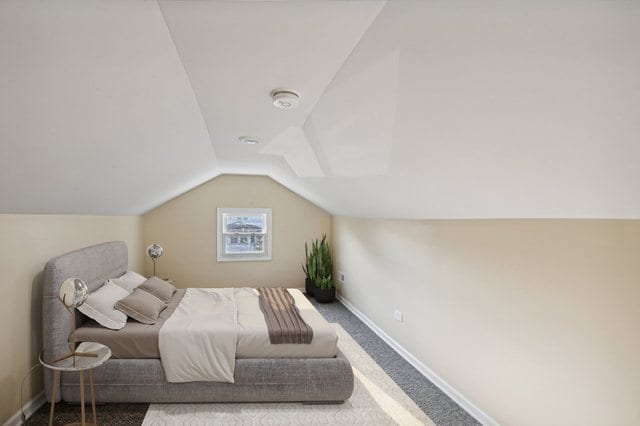 carpeted bedroom with lofted ceiling