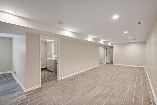 basement featuring light wood-type flooring and sink