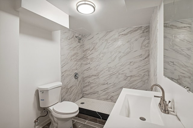 bathroom featuring toilet, sink, and tiled shower