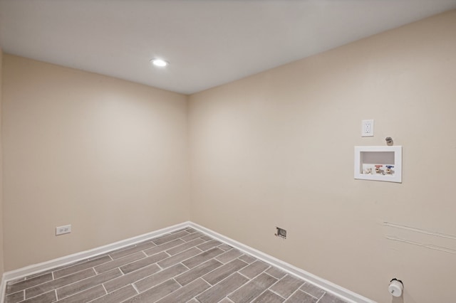 clothes washing area with hardwood / wood-style flooring and hookup for a washing machine