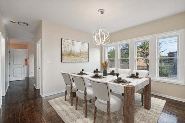 dining space with an inviting chandelier and dark wood-type flooring