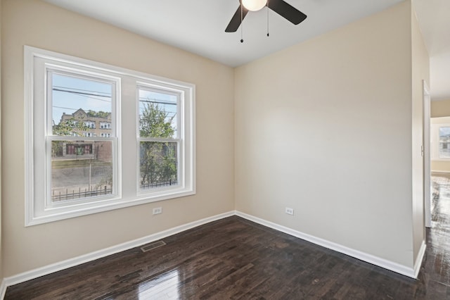 spare room featuring dark wood-type flooring and ceiling fan