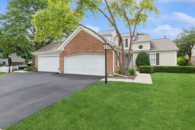 view of property featuring a garage and a front lawn