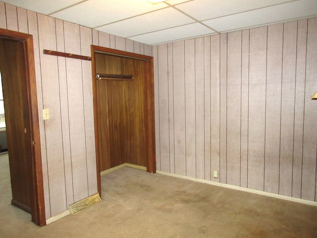 interior space featuring a closet, light colored carpet, and a drop ceiling