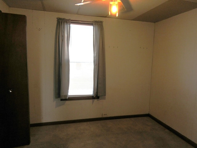 carpeted spare room with ceiling fan