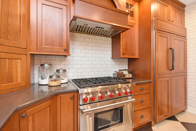 kitchen with dark stone counters, backsplash, custom exhaust hood, and high end appliances