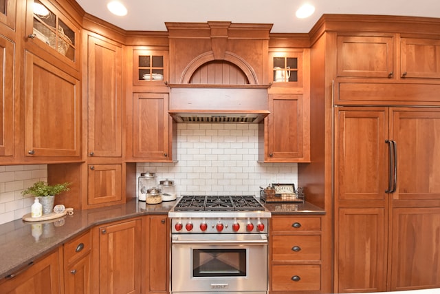 kitchen with luxury range, dark stone countertops, custom range hood, and tasteful backsplash