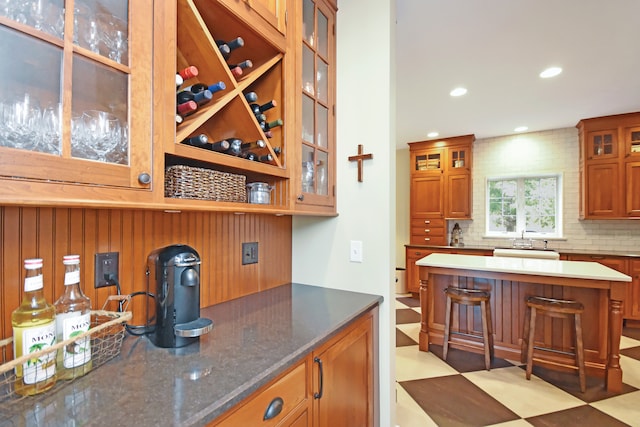 kitchen featuring dark stone counters, sink, and decorative backsplash