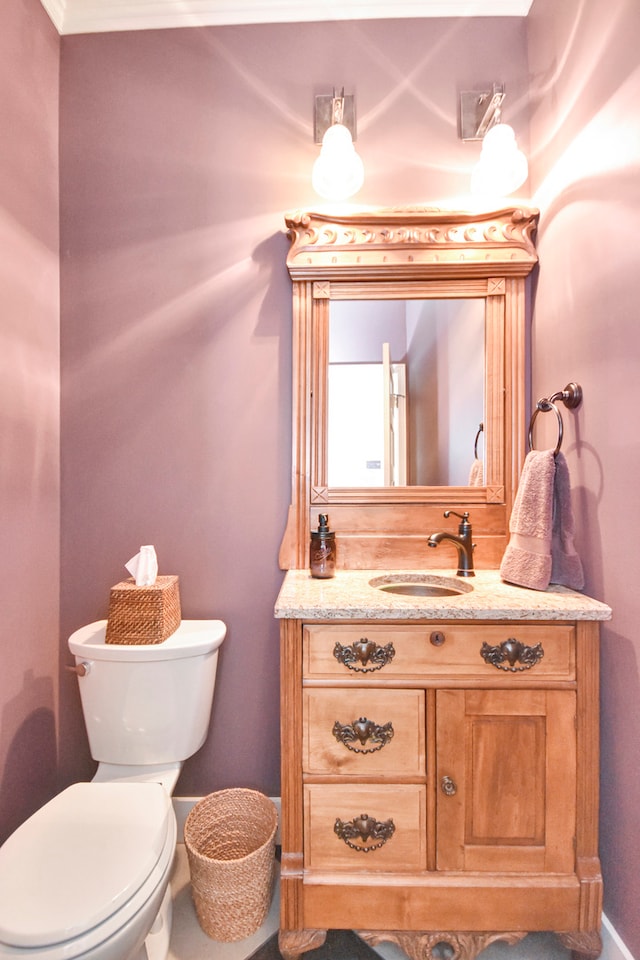 bathroom featuring vanity, toilet, and crown molding