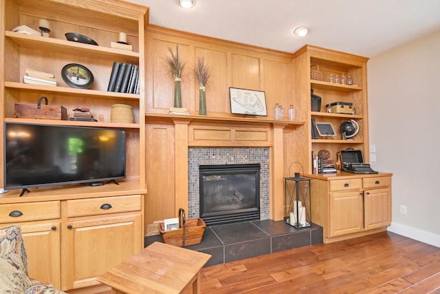 living room featuring hardwood / wood-style floors and a tile fireplace