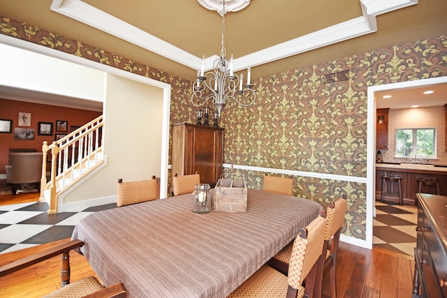 dining area featuring a notable chandelier, dark hardwood / wood-style floors, and crown molding