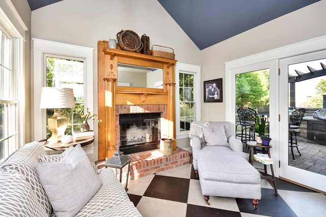 living room with a fireplace and high vaulted ceiling