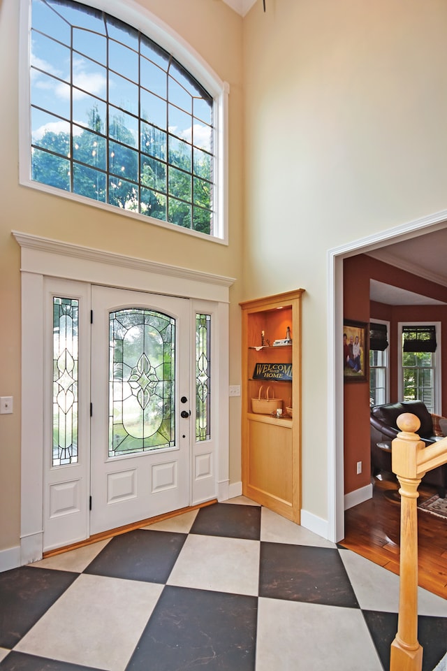 entrance foyer featuring hardwood / wood-style floors and a towering ceiling