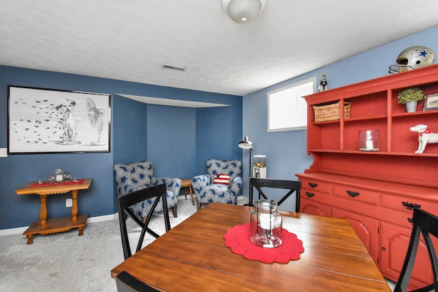 dining space with a textured ceiling and carpet flooring