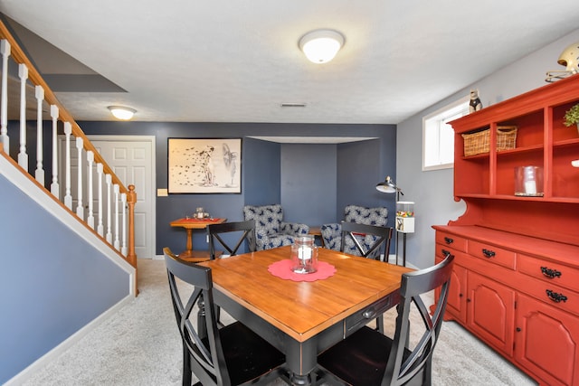 dining room featuring light colored carpet and a textured ceiling