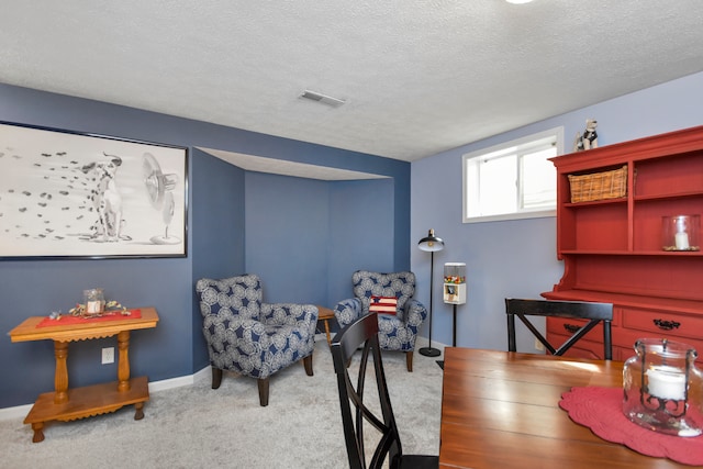 carpeted office space featuring a textured ceiling