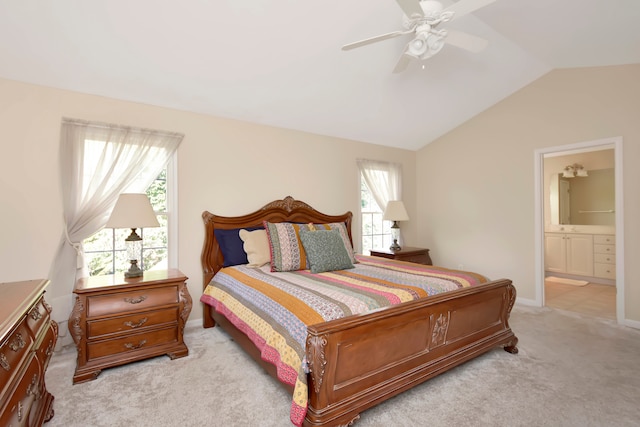 carpeted bedroom with ensuite bath, ceiling fan, multiple windows, and lofted ceiling